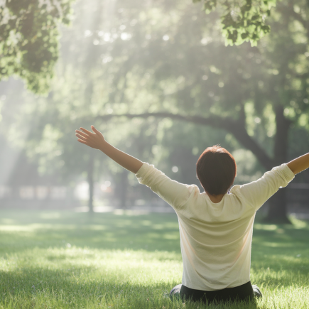 parc-verdoyant-personne-dos-bras-ouverts